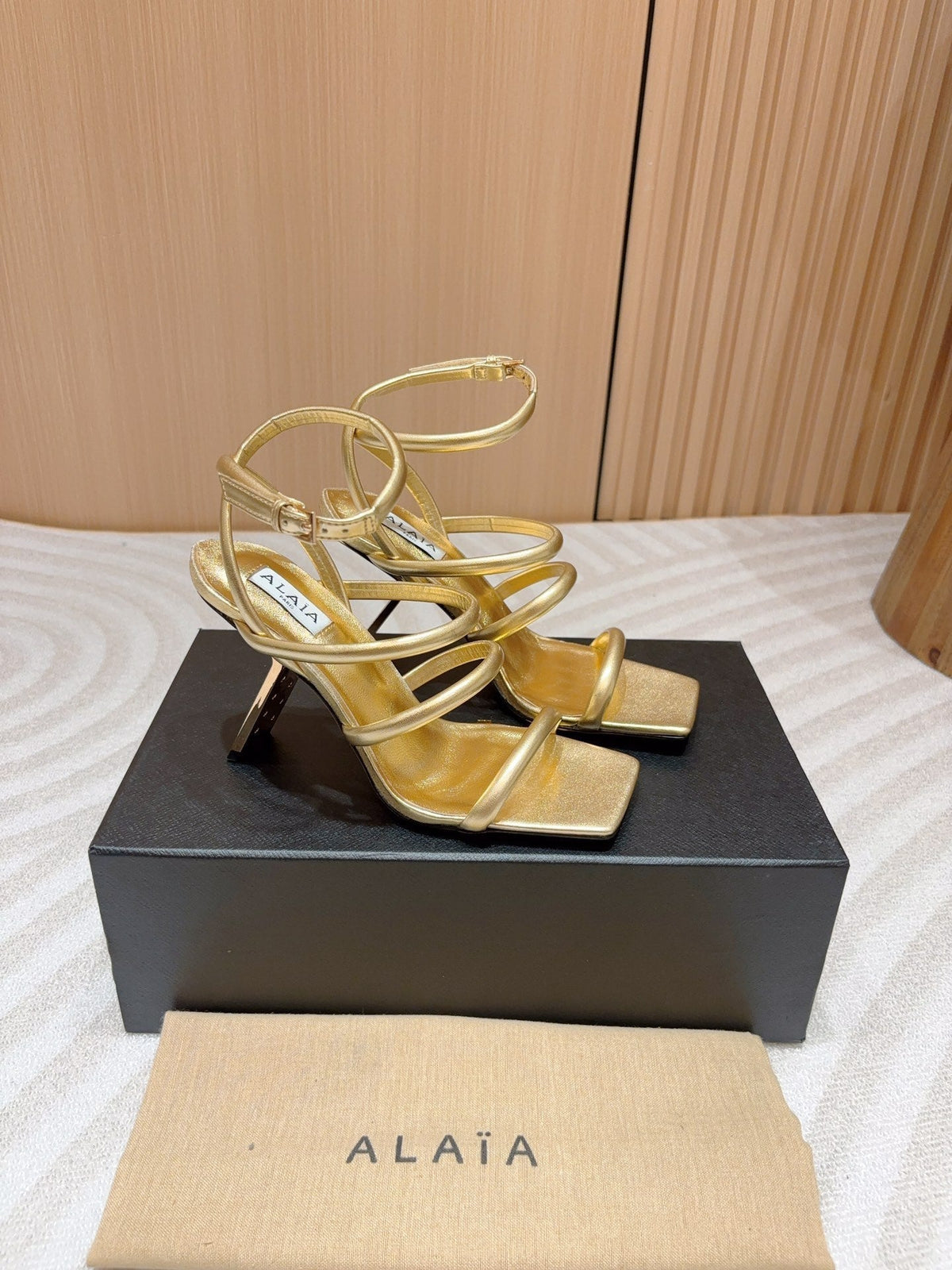 ALAIA THREE-STRAPS HIGH HEEL SANDALS IN GOLDEN PATENT LAMBSKIN